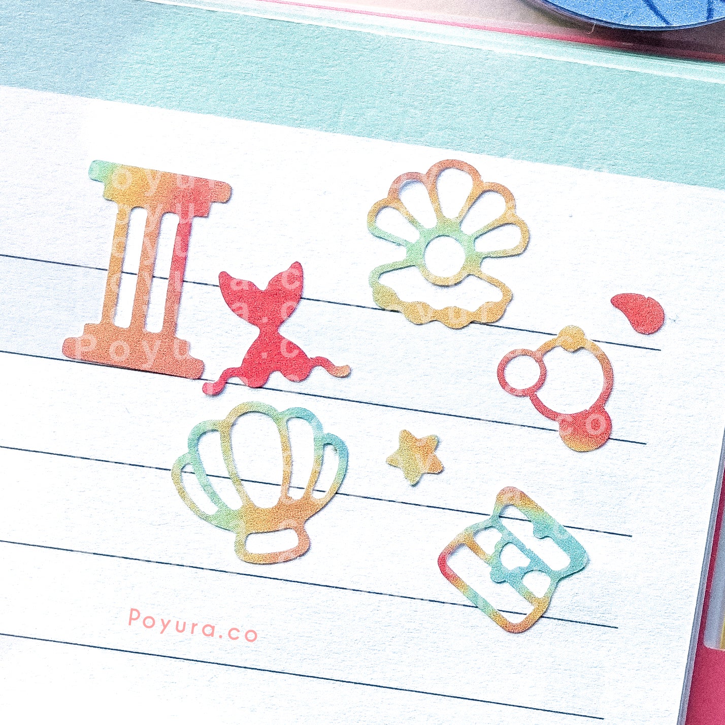 Borderless sticker with ocean Atlantis cutouts in different red, orange, and green tints on a journal