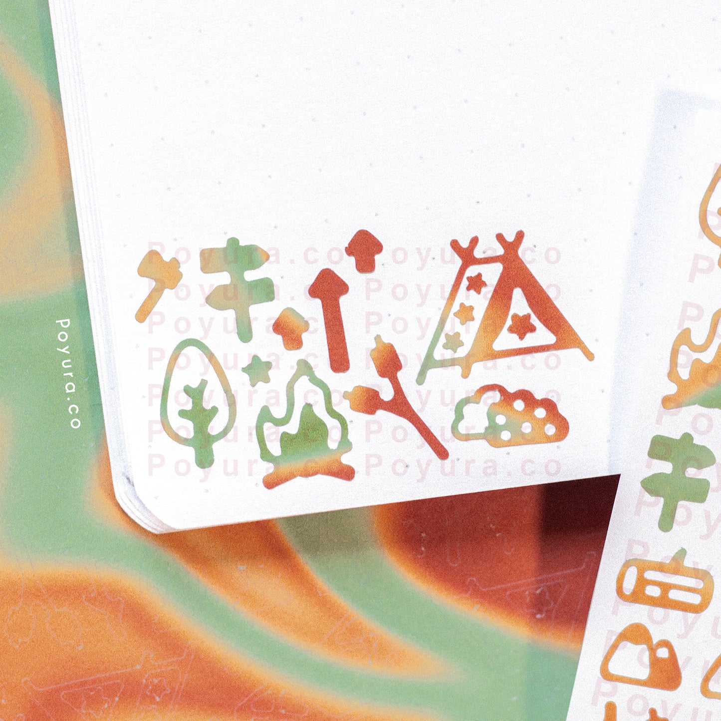 Closeup of borderless sticker with camping and tree cutouts in different red and green tints