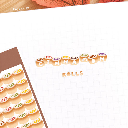 Stickers of cute cinnamon rolls with alphabet letter cutouts on a journal