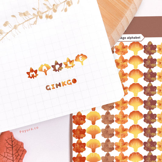Stickers of cute fall maple and ginkgo with alphabet letter cutouts on a journal