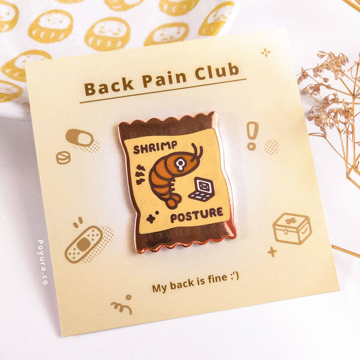 Pin with a shrimp design featuring back pain, paired with a matching card with decorative elements.