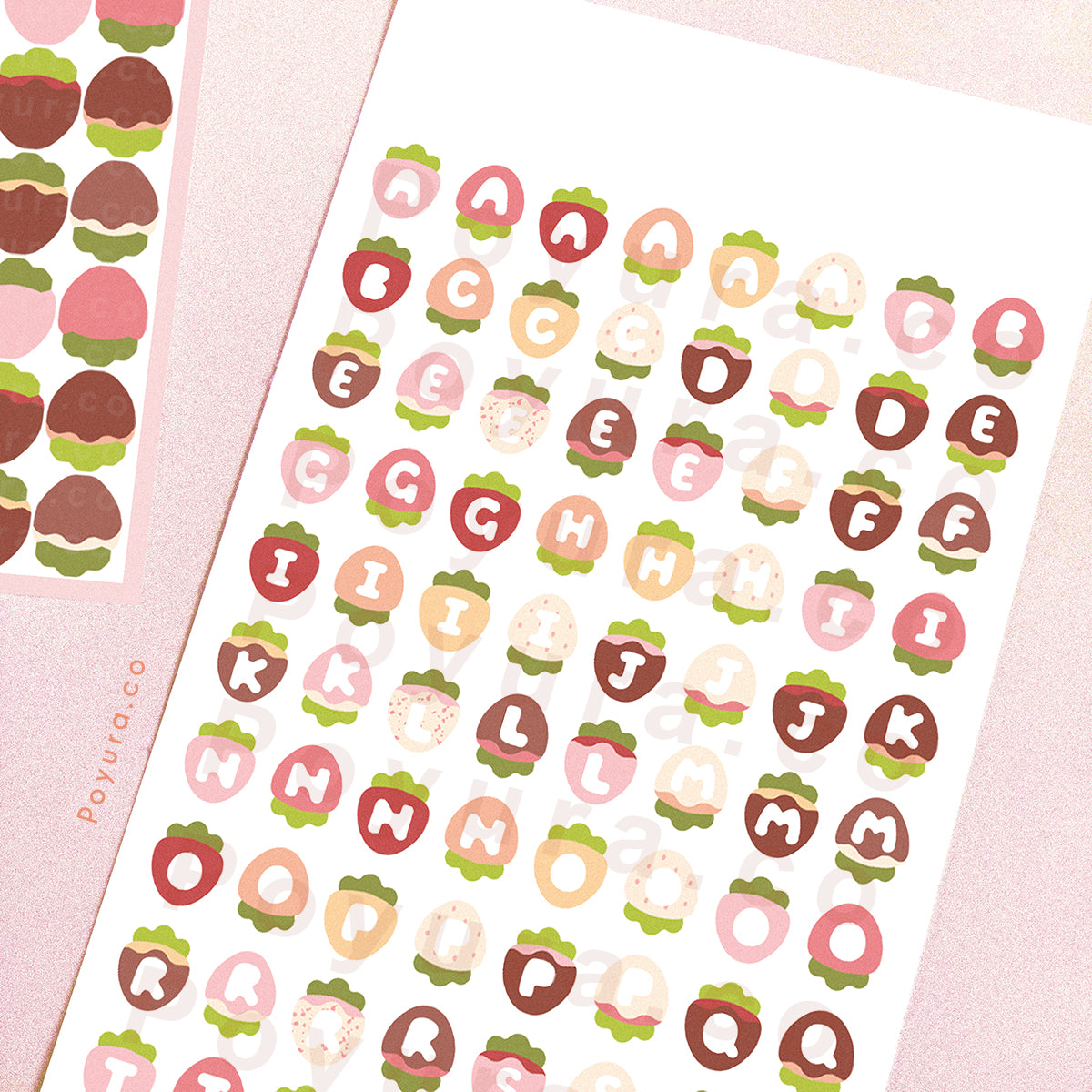 Sticker sheet of strawberries with alphabet letter cutouts in the center.