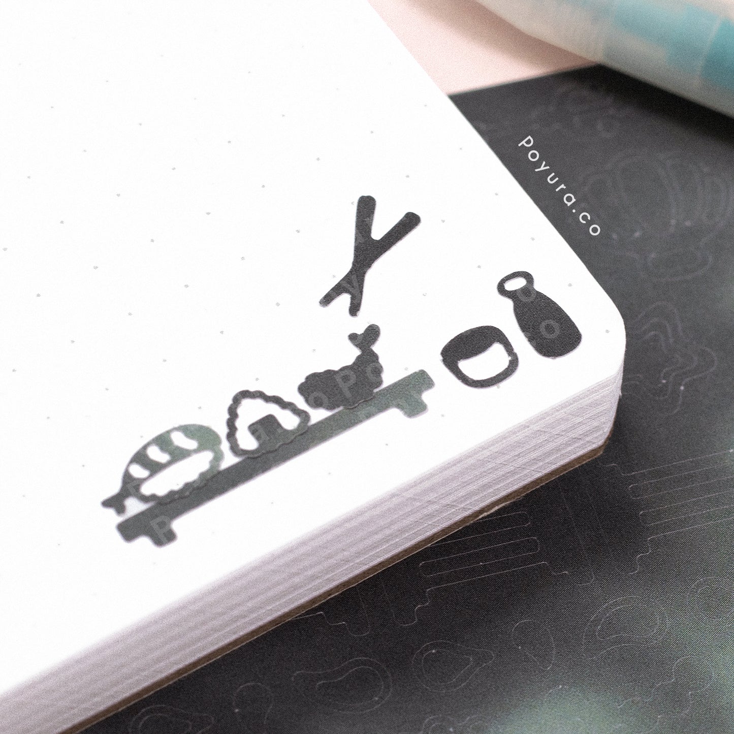 Borderless stickers with sushi and rice cutouts in different grey tints on a journal