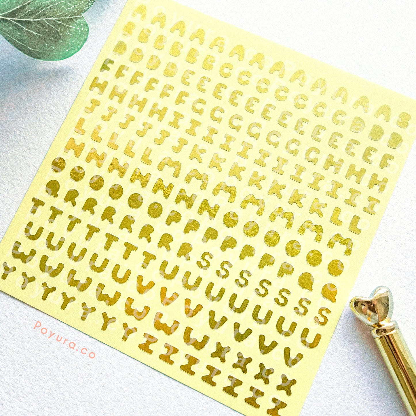 Borderless sticker with uppercase alphabet letter cutouts in gold foil