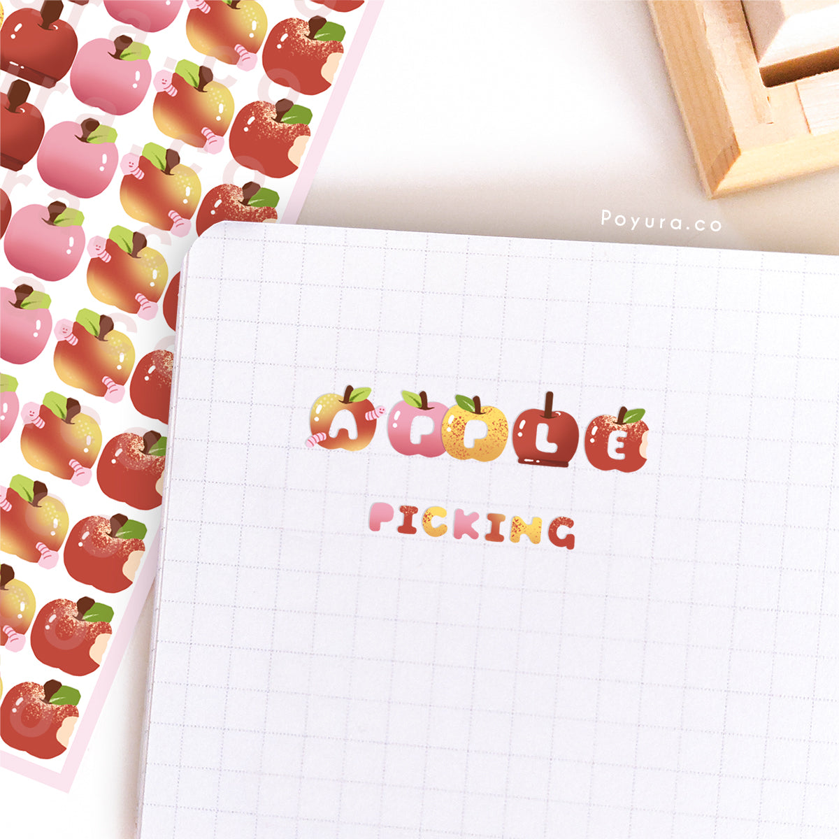 Stickers of cute apples with alphabet letter cutouts on a journal