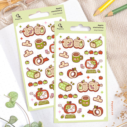 Apple stationery-themed sticker sheet on an open notebook. The desk is decorated with pencils, a scissor, and some plants.