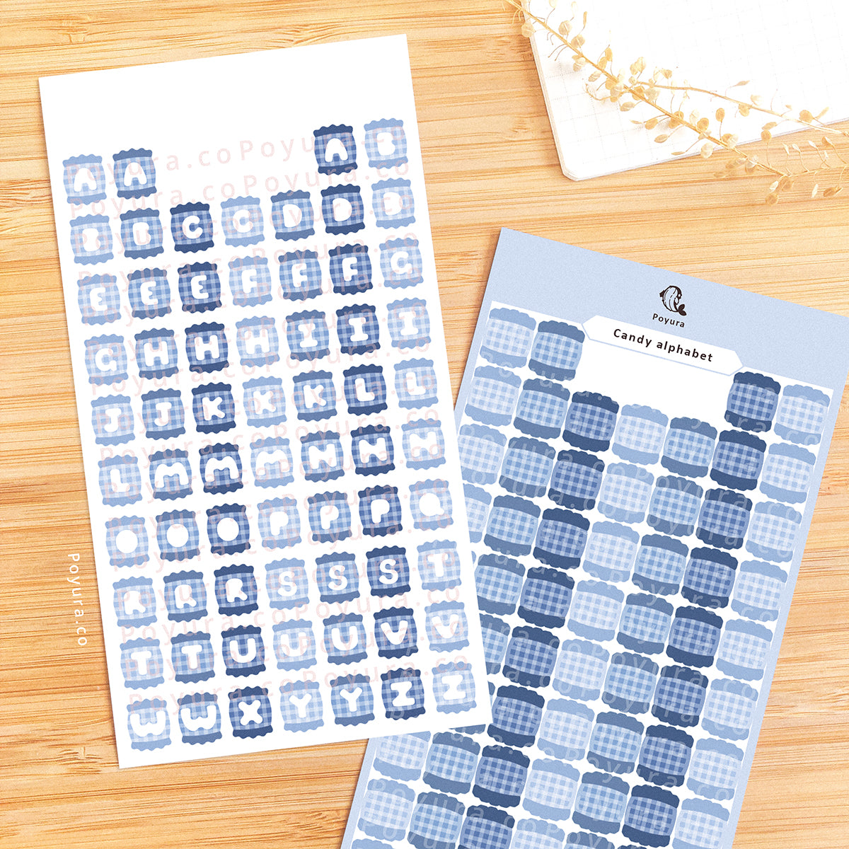 Two sticker sheets of blue candies with alphabet letter cutouts in the center.