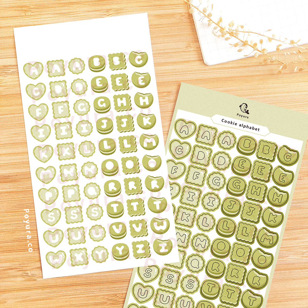 Sticker sheet of green cookies with alphabet letter cutouts in the center.