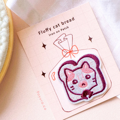 A cute red embroidery patch of bread with a cat head poking out with packaging