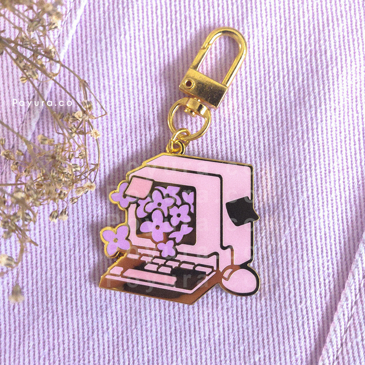 An enamel keychain of a cute retro computer with purple hydrangea