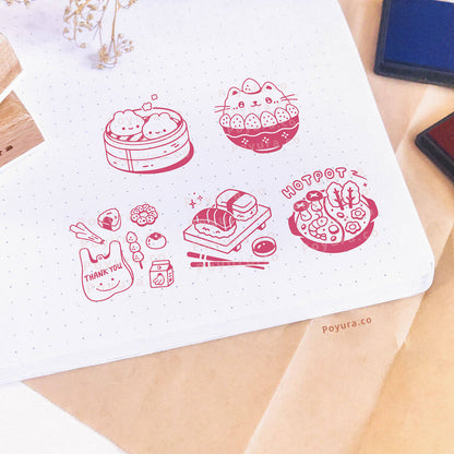 A notebook is stamped with Asian food-themed decoration. A red ink pad was used for the stamps.