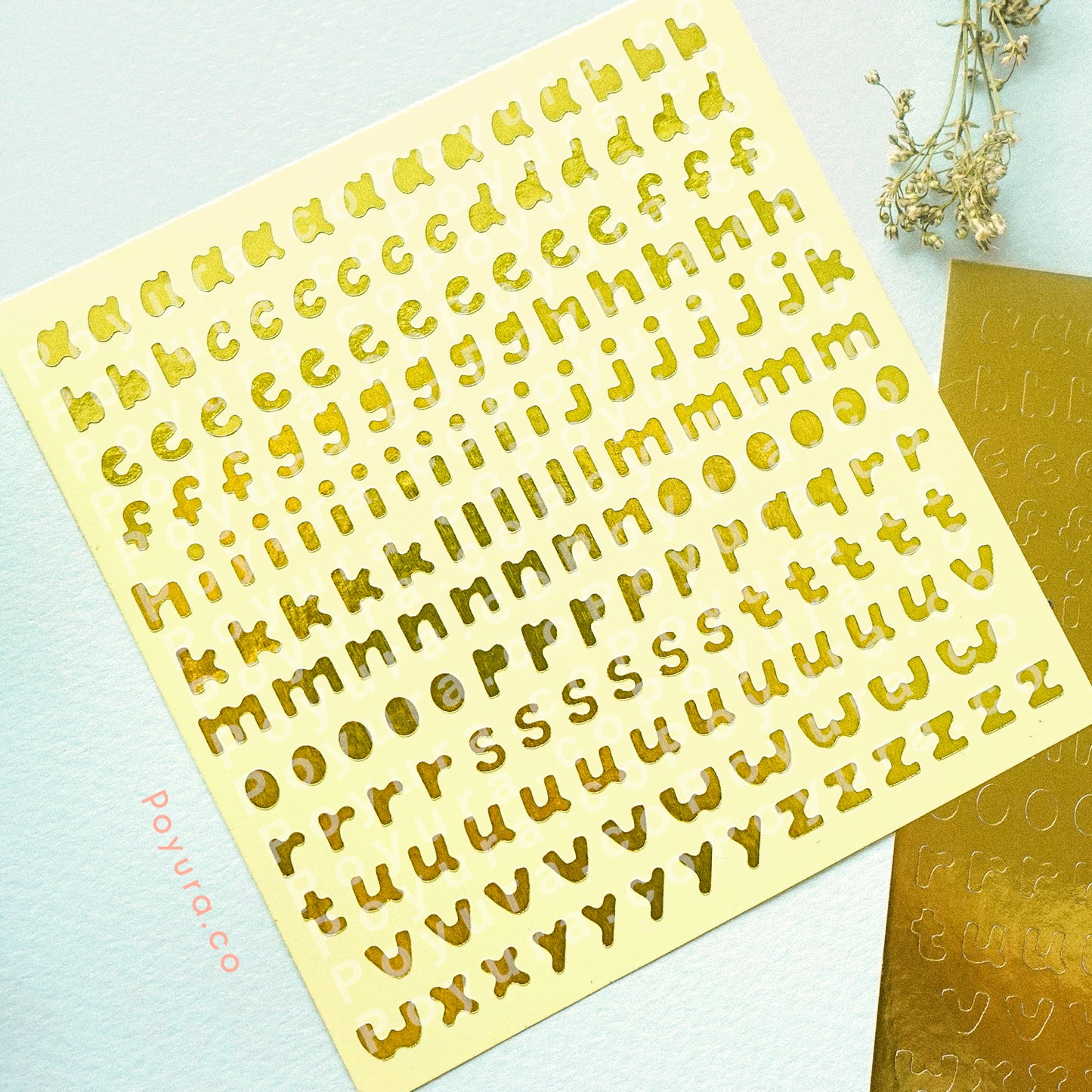 Borderless sticker with lowercase alphabet letter cutouts in gold foil