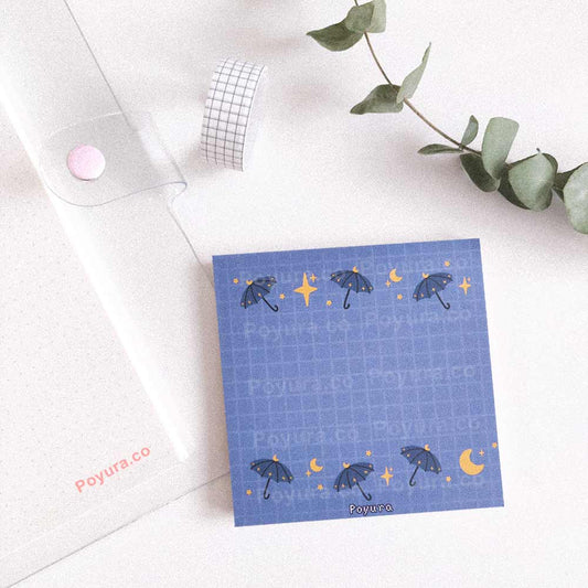 Blue memo notepad with a grid and magical umbrellas