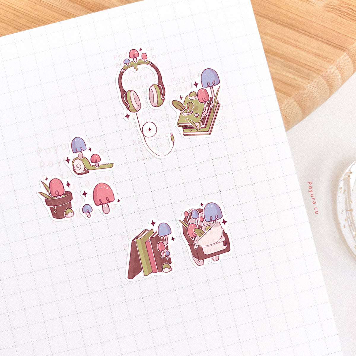 Stickers of cute mushrooms on books headphones and school bags on a journal