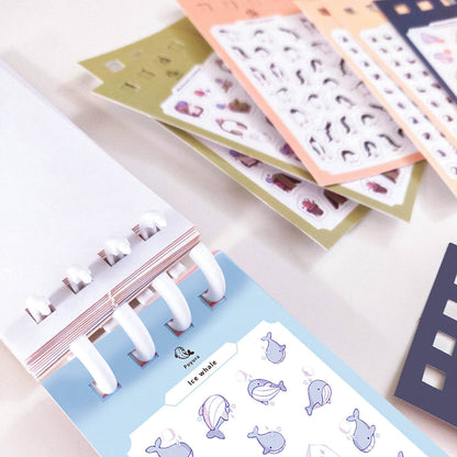 Collection of tiny sticker sheets with various designs on a white surface