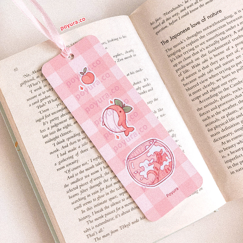Peach whale bookmark in a book