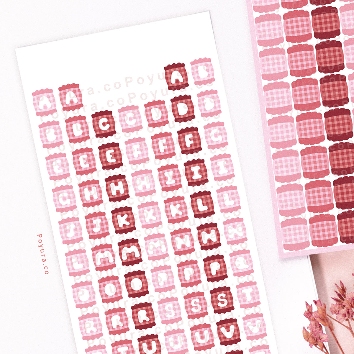 Two sticker sheets of pink candies with alphabet letter cutouts in the center.