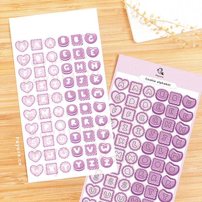 Sticker sheet of purple cookies with alphabet letter cutouts in the center. 