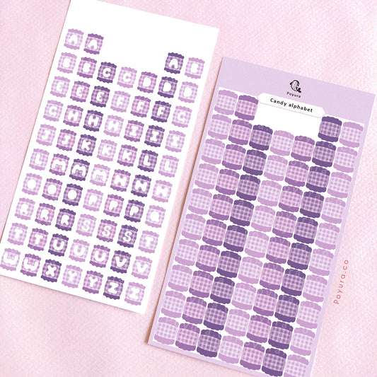 Two sticker sheets of purple candies with alphabet letter cutouts in the center.