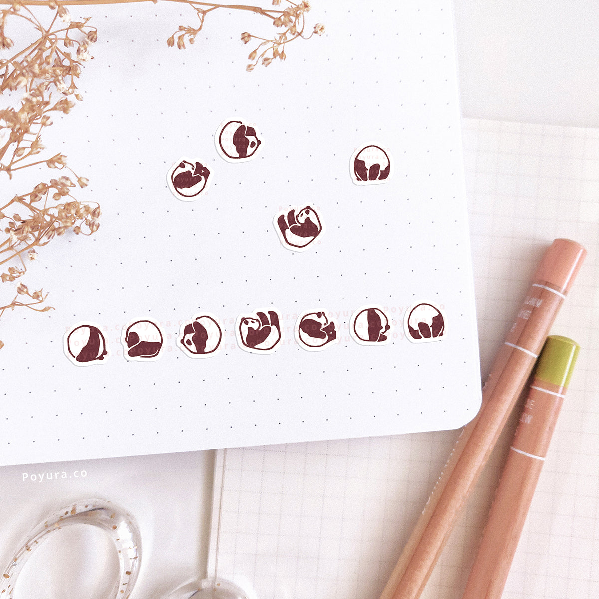 Stickers of cute rolling pandas on a journal