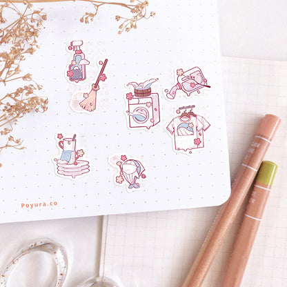 A journal spread decorated with sakura cleaning sticker. There are cleaning supplies, a broom, laundry, washing machine, dishes, and whale dusting. Everything is decorated with sakura.