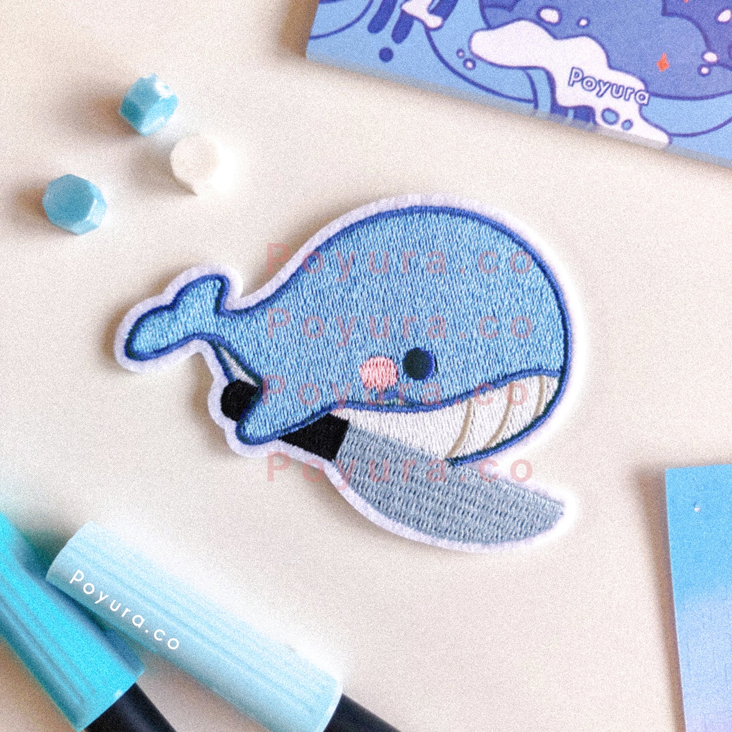 Iron on embroidery patch of a blue whale with a knife