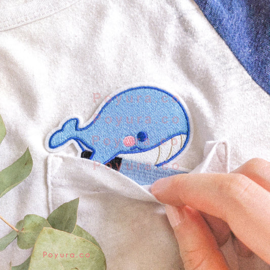 Iron on embroidery patch of a blue whale with a knife