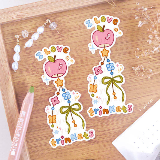 Decorative wind chime sticker with 'I Love trinkets' text on a wooden surface.