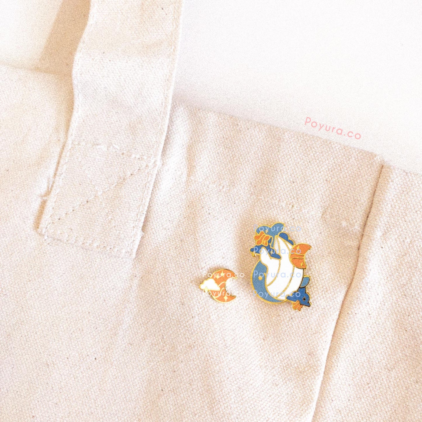 Closeup of whale and moon enamel pins on tote bag