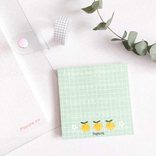 Green square memo notepad with grid, yuzu and flowers